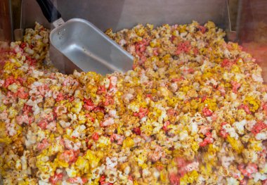 Lezzetli patlamış mısır üretimi için güzel bir araba. Farklı renkte bir karamelli mısır yığını. arkaplan