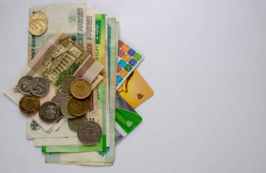 Rus banknotları, bozuk paralar ve banka kartları beyaz arka planda. Kapat..