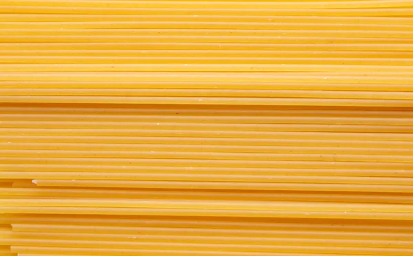 黄色のドライスパゲティ 細いパスタが横に並べられています 黄色のイタリアパスタ 細いスパゲティ 食の背景の概念 — ストック写真