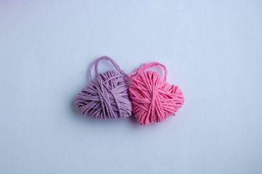 Anneler Günü, pembe ve kalp şeklinde eflatun örgü ipliği. Sevgililer Günü, 8 Mart, minimum konsept. Beyaz arka planda kalbi olan bir tebrik kartı. Yukarıdan görünüşü.