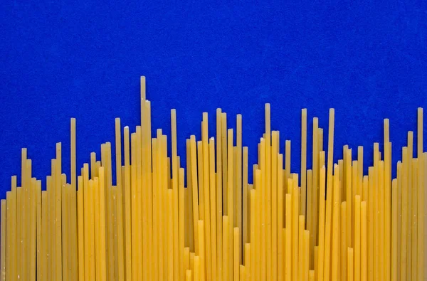 Fundo Espaguete Pasta Amarela Isolada Fundo Azul — Fotografia de Stock