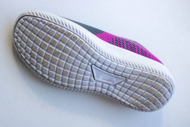 Yeni spor ayakkabısının tabanı biraz kirlenmiş, beyaz arka planda izole edilmiş..