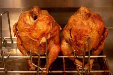 İki tane ızgara tavuk leşi pencerenin arkasında oturur. marcet.