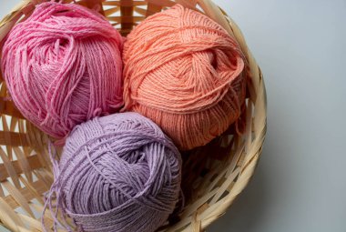 Beyaz arka planda sepetteki renkli iplik yumakları.