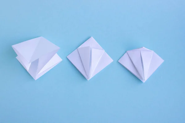 Peixe de origami de papel poligonal geométrico moderno branco artesanal em fundo azul.Passo 2 . — Fotografia de Stock