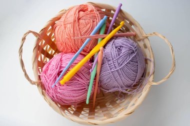 Beyaz arka planda sepetteki renkli iplik yumakları.