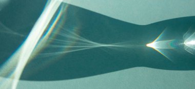 Soyut görüntü, güneş turkuaz arka planda bir bardak suyun içinden parıldıyor..