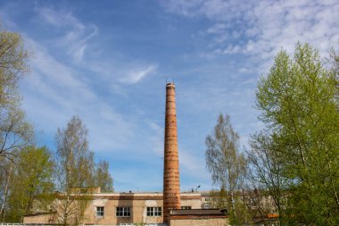 Açık mavi gökyüzüne karşı eski bir kazan dairesinin bacası..