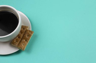 Cyan mavi ve yeşil arka planda kurabiyeli kahve fotoğrafı.