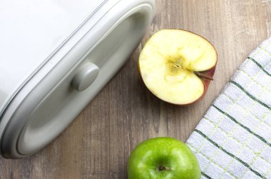 Mutfak masasındaki ahşap arka planda iki dilim yeşil elmanın fotoğrafı.