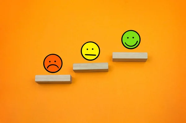 Sad and Smile emoticons grow up success on the orange background copy space and drawing emoticons
