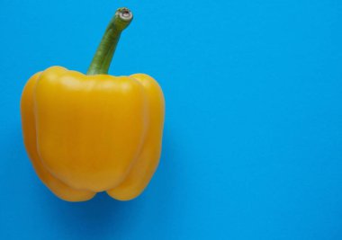 Mavi, katı arkaplanda, kopyalama alanı olan sarı biber.