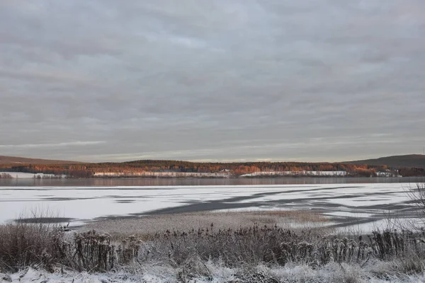 Winter landscape in Sweden. Frozen cold lake with snow and ice. Cloudy winter day.