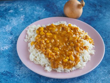 Kırsal mavi arka planda vejetaryen güveci ile pilav.