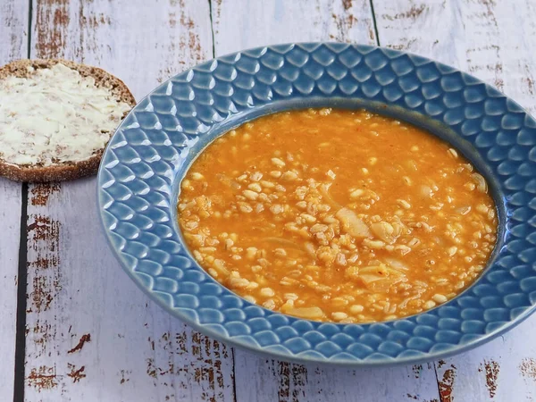 Home made vegetarian lentil soup with a slice of dark rye bread on the side. White rustic wooden background. — Stock Image Home Made Vegetarian Lentil Soup Slice Dark Rye Bread Side Stock Photo