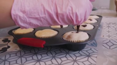 Eldivenli çocuklar Cadılar Bayramı için bir resimle topkek süslüyor.