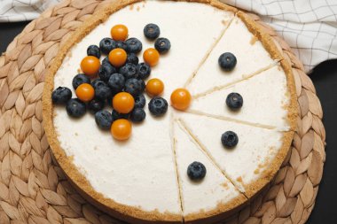 Dilimlenmiş ve böğürtlenlerle süslenmiş kremalı peynirli kek. Ev yapımı pişirme. Doğum günü pastası