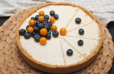 Dilimlenmiş ve böğürtlenlerle süslenmiş kremalı peynirli kek. Ev yapımı pişirme. Doğum günü pastası