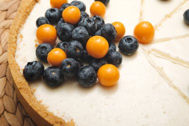 Dilimlenmiş ve böğürtlenlerle süslenmiş kremalı peynirli kek. Ev yapımı pişirme. Doğum günü pastası