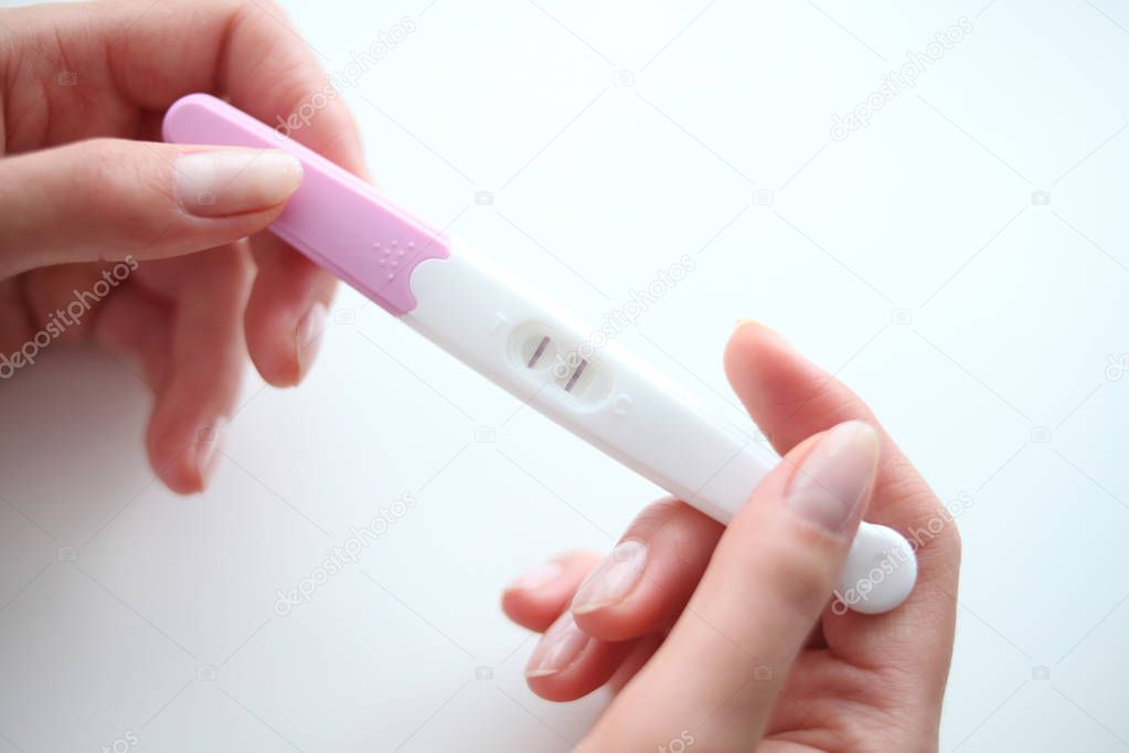 Woman is holding in hands pregnancy test.
