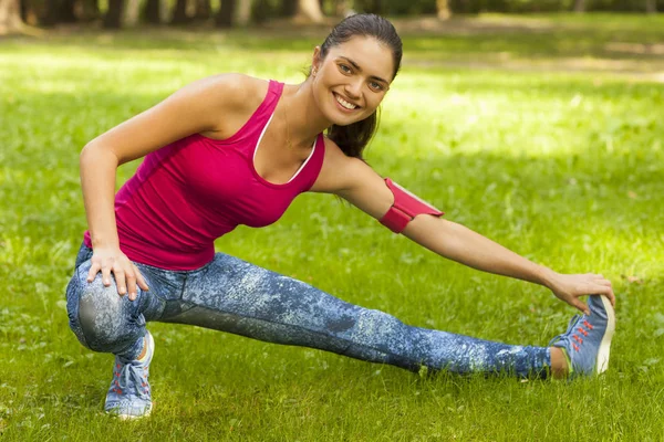 Young woman stretching her body in the park. — Stock Photo, Image