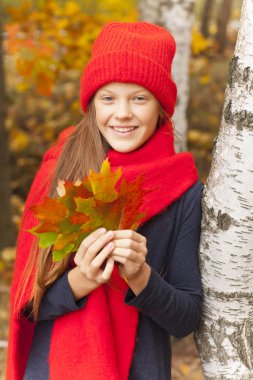 Genç sarışın kız parkta altın sonbahar keyfi.