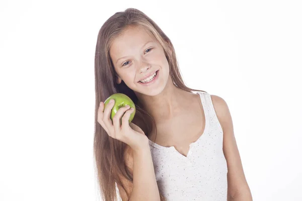 Junges Mädchen beißt in einen grünen Apfel. — Stockfoto