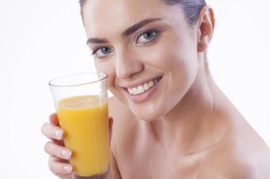 Güzel kadın portakal suyu içiyor.