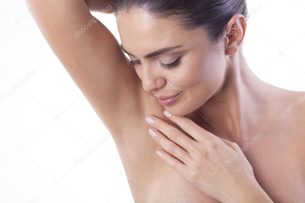 Close up of young woman showing her smooth armpit.