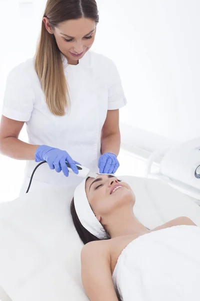 Hermosa mujer está teniendo un tratamiento facial en spa . — Foto de Stock