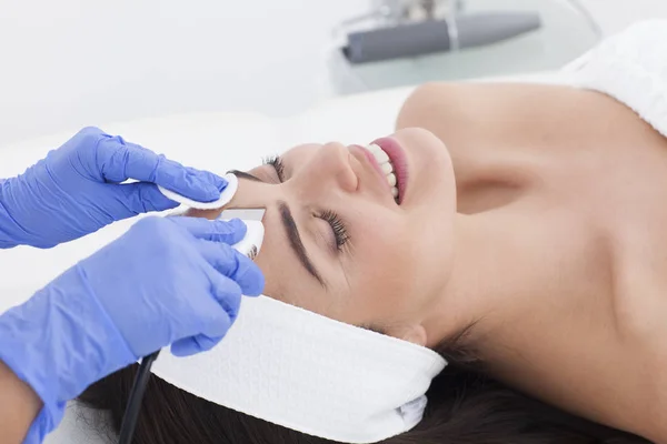 Hermosa mujer está teniendo un tratamiento facial en spa . — Foto de Stock