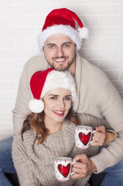 Gülümseyen iki sonra Santa şapka ve Noel Kupası.