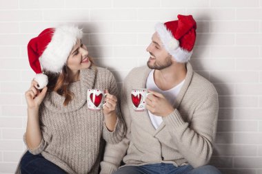 Gülümseyen iki sonra Santa şapka ve Noel Kupası.