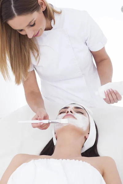 Mujer es spa con máscara en su cara . — Foto de Stock