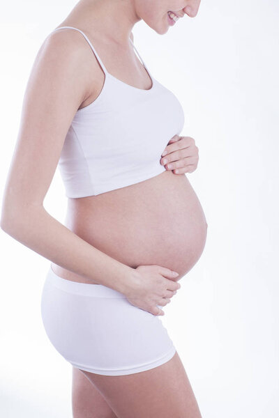 The picture of baby bump isolated on pink background. The happiness of waiting for a new family member.