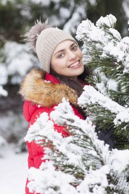 Güzel kadın parkta kar yağışı sırasında mutludur.