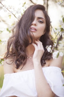 Çiçeği ağaçlarıyla çevrili güzel gülümseyen kız.