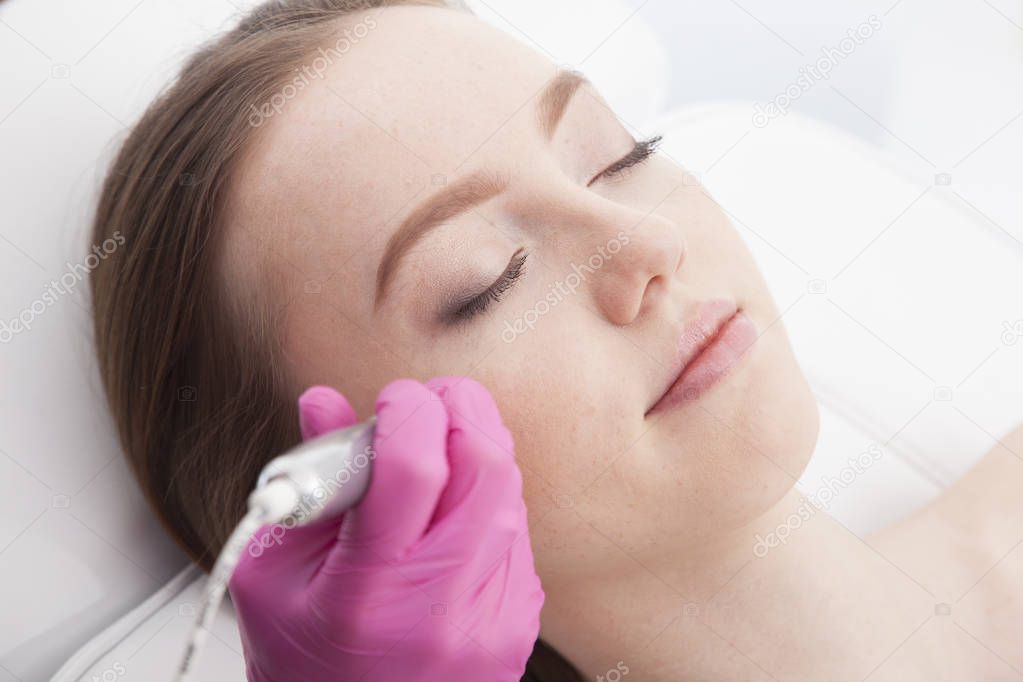 Beautiful, young woman having a treatment of her head's skin.