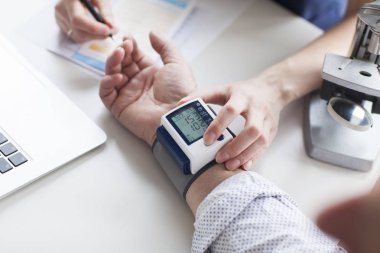Onun büyük hasta baskısı inceleyerek genç kadın doktor. Hipertansiyon.