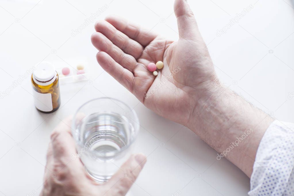 Close up of male hand holding a vitamins and supplements. Medication in male hand.