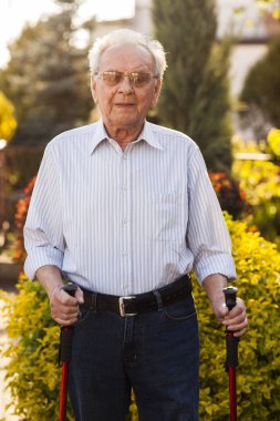 Yaşlı adamın bahçede mutlu ve ayakta.