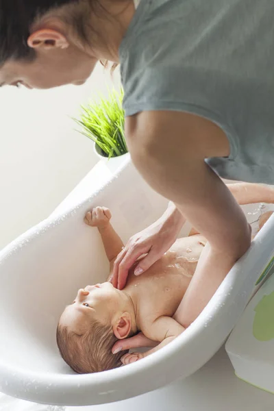 小婴儿正在她母亲的怀抱里洗澡 — 图库照片