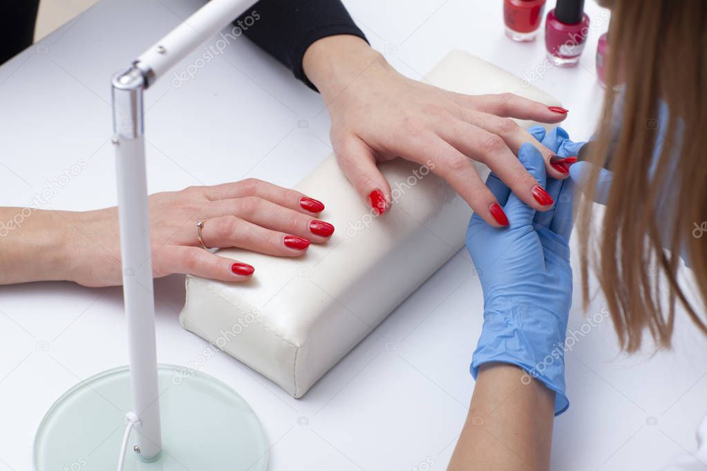 Woman doing a professional manicure at spa saloon.