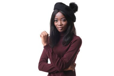 Beyaz arka planda siyah şapkalı çekici Afro-Amerikan modelinin portresi.