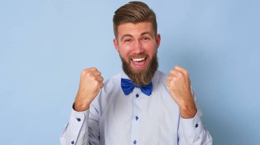 Süper mutlu genç adam yumruklarını sıkıca sıkıyor..