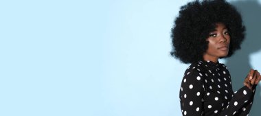 Siyah golfte Afro-Amerikan modeli. Mavi arka planda beyaz noktalar var..