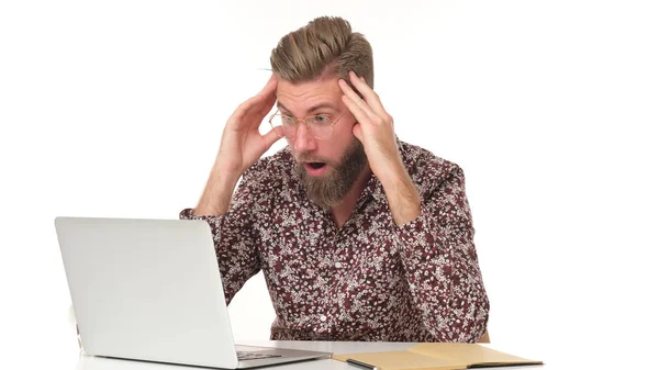 穿着花纹衬衫留着胡子的男人不敢相信坐在电脑前会发生什么事 — 图库照片