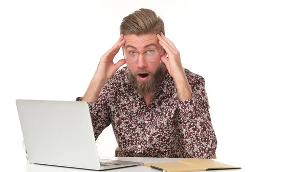 穿着花纹衬衫留着胡子的男人不敢相信坐在电脑前会发生什么事 — 图库照片