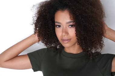 Beyaz arka planda koyu yeşil elbiseli afro saçlı güzel bir manken..