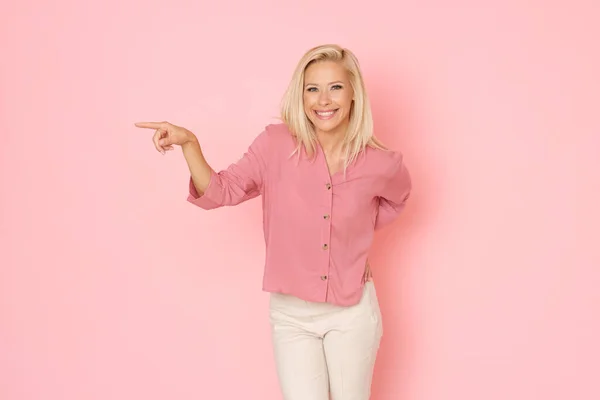 Glad Blond Trevlig Flicka Rosa Skjorta Visar Något Sidan — Stockfoto